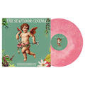 A baby pink marbled galaxy vinyl rests beside its cover, which shows a cherub amidst vibrant flowers, greenery, and THE SEAFLOOR CINEMA—an ideal pick for any The Seafloor Cinema vinyl collector.