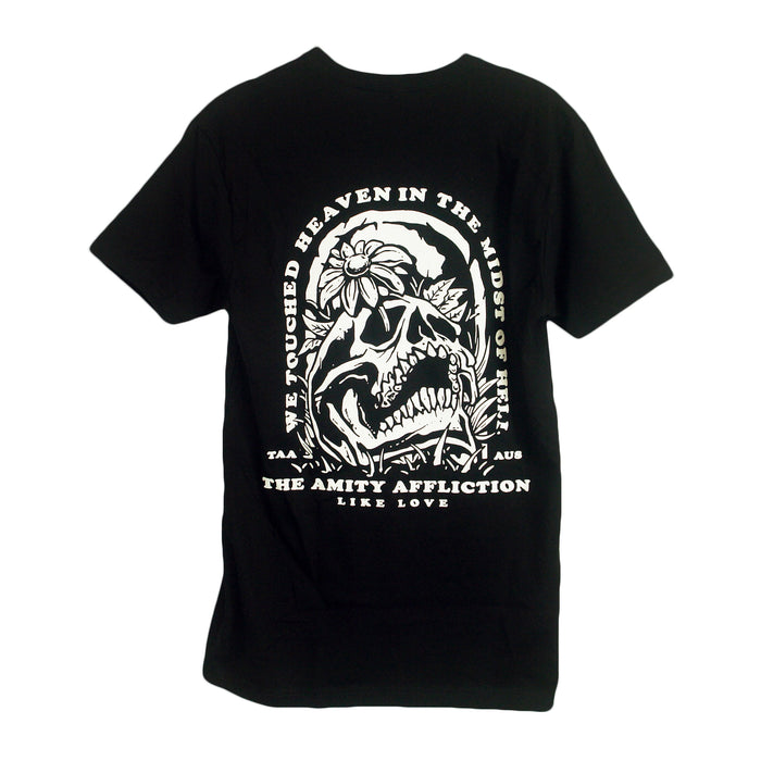 Black t-shirt by The Amity Affliction featuring a white graphic of a skull, flowers, and leaves with the text: WE TOUCHED HEAVEN IN THE MIDST OF HELL and LIKE LOVE, plus TAA and AUS on the sides.