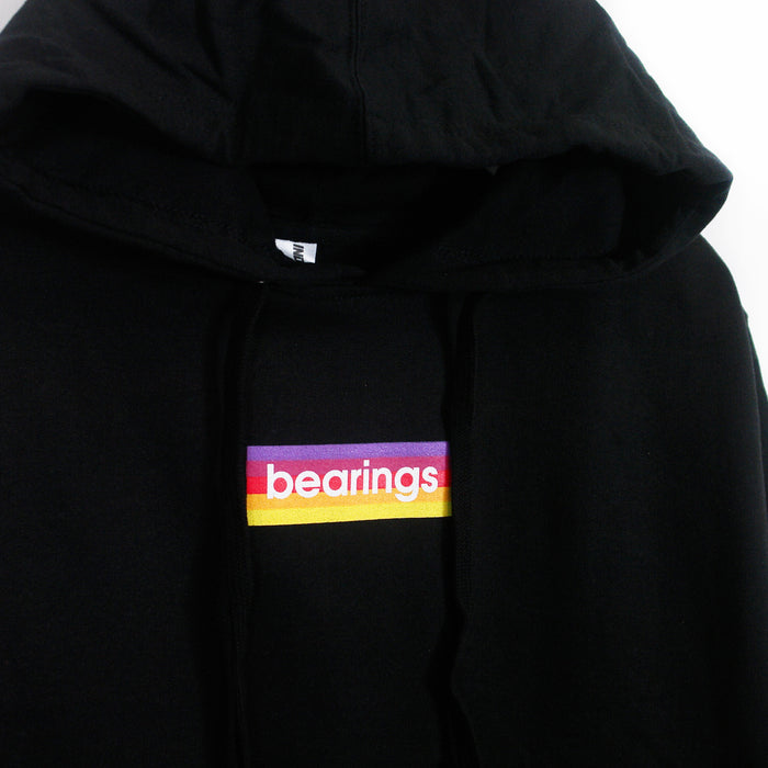 This black midweight pullover hoodie by Bearings features a chest graphic with bearings in white lowercase over pink, red, orange, and yellow stripes.