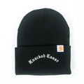 A black winter knit beanie by Knocked Loose featuring white Gothic logo embroidery on the folded brim and a small Carhartt label on the side.