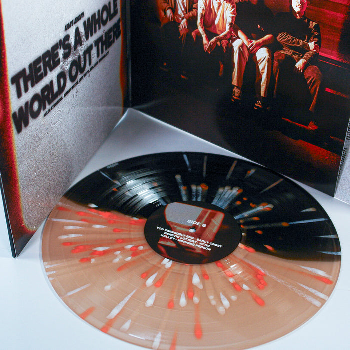 A limited edition Arm's Length vinyl with a black center and red-white splatter sits by an open album cover showing "THERES A WHOLE WORLD OUT THERE" and four people. Only 1500 units made in this 2nd Press.
